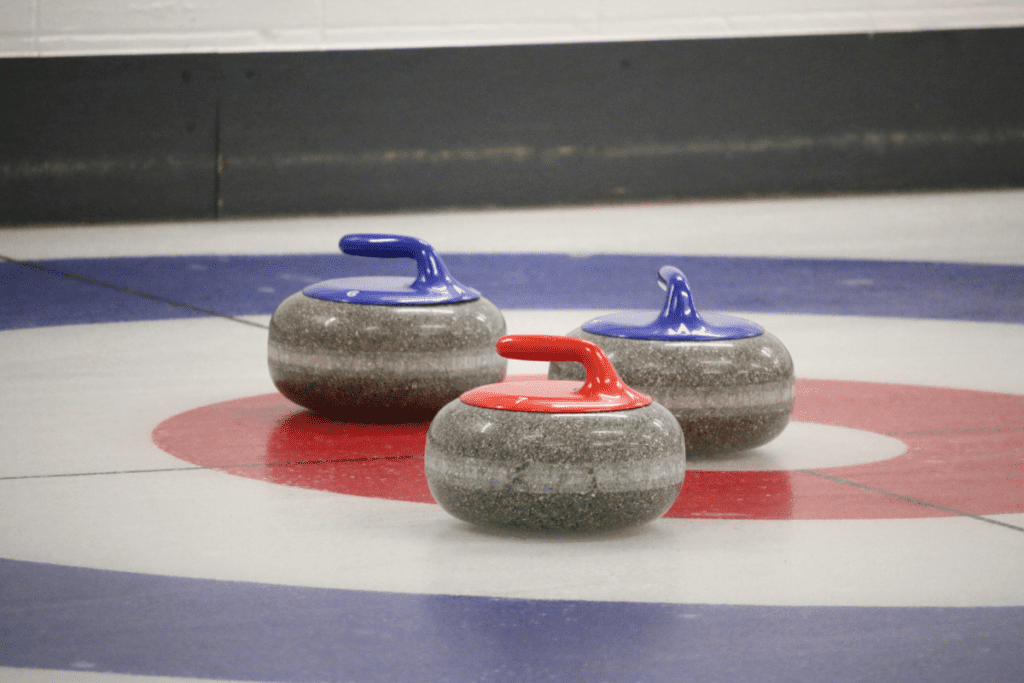 Three curling rocks on a curling rink as an example for kirkcaldy ice rink also known as fife ice arena scotland uk