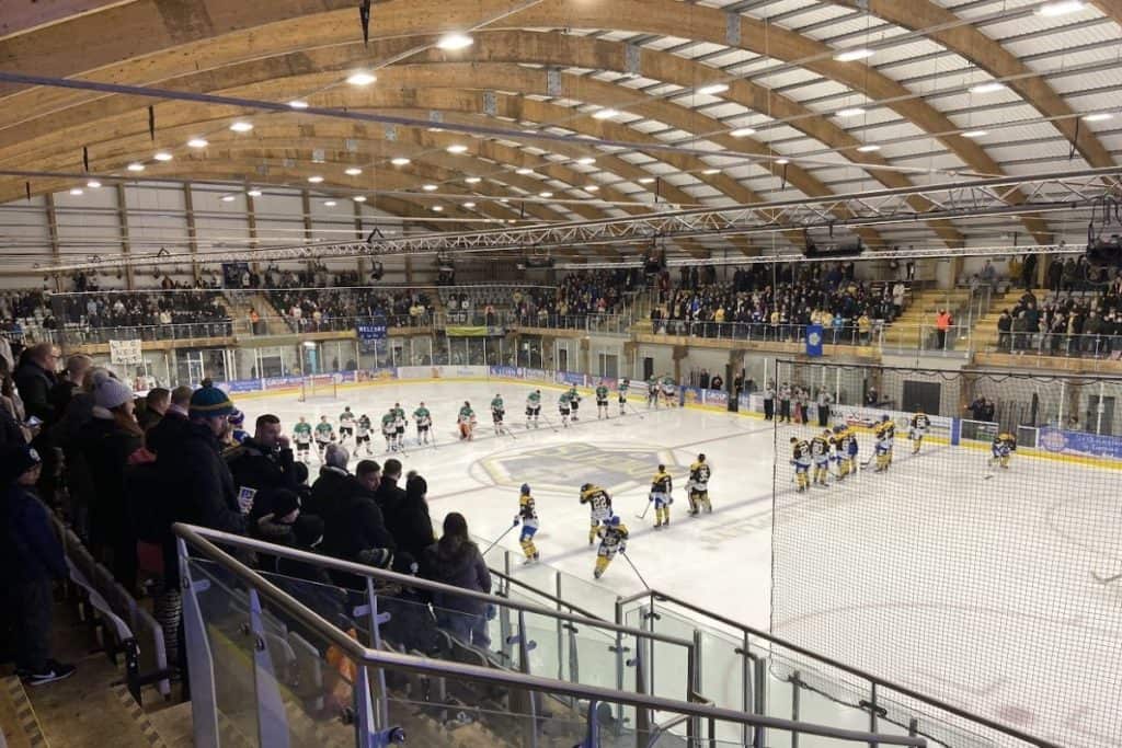 Leeds knights ice hockey team line up against basingstoke bison in front of spectators at planet ice leeds ice rink uk