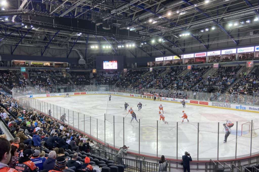 Belfast giants team take on sheffield steelers in an ice hockey game at sse arena ice rink northern ireland in front of a large crowd of spectators